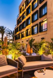 eine Hotelterrasse mit Sofas und ein Gebäude in der Unterkunft Brown Eilat a member of Brown Hotels in Eilat