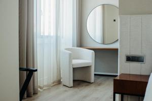 baño con silla blanca y espejo en Next Level Premium Hotels en Lisboa