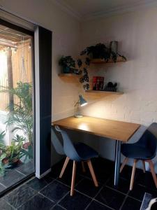 - une table en bois et 2 chaises bleues dans une chambre dans l'établissement Hide Away on 21, à Mossel Bay