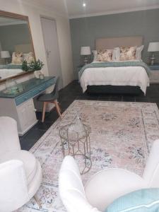 a bedroom with a bed and a table and a mirror at Hide Away on 21 in Mossel Bay