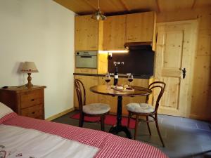 Zimmer mit einem Tisch und 2 Stühlen sowie einer Küche in der Unterkunft Chez Pierre in Praz-de-Fort