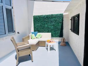 patio ze stołem i krzesłami oraz zieloną ścianą w obiekcie Apartment for special getaway Rose w Puli
