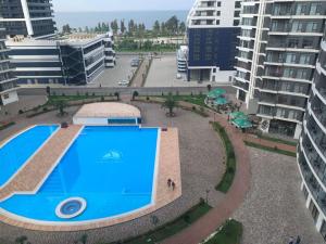 uma piscina no meio de uma cidade com edifícios em Cozy Studio Swimming Pool And Jacuzzi em Batumi