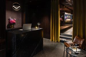 a room with a desk with a laptop and a chair at Hotel MANI by AMANO in Berlin