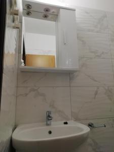 a bathroom with a white sink and a mirror at APARTMANI JURIĆ in Trpanj