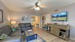 un soggiorno con divano e TV a schermo piatto di GOLDEN DAYS DUPLEX Duplex a Jekyll Island
