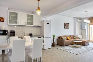 a kitchen and living room with a table and chairs at Casa Del Mar 2 Mamaia Nord in Mamaia