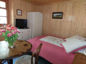 a small room with a table with a vase of flowers at Chez Pierre in Praz-de-Fort