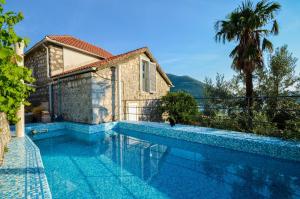 a villa with a swimming pool in front of a house at Villa Bocca del Perasto in Perast
