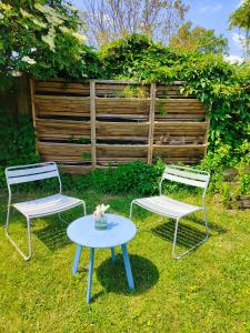 two chairs and a table in the grass at Hôtel Restaurant La Voile Bleue in Erdeven