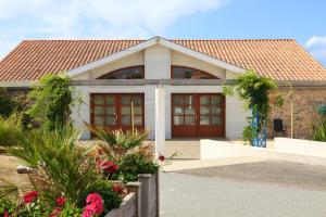 Casa blanca con techo rojo en Oasis Les Jardins des Sables d'Olonne, en Les Sables-dʼOlonne