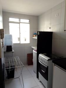 uma pequena cozinha com um fogão e uma janela em AP - Arretado em Campina Grande