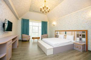 a hotel room with a bed and a desk and a room at Nohur Hotel Gabala in Gabala