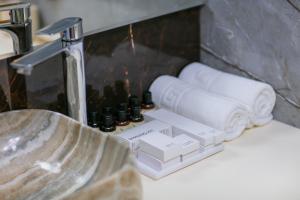 a bathroom sink with towels and a faucet at Nohur Hotel Gabala in Gabala