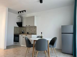 una cucina con tavolo, sedie e frigorifero di Skyline apartment a Sinemorets