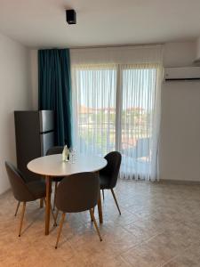 una sala da pranzo con tavolo, sedie e una finestra di Skyline apartment a Sinemorets Altre 70 foto