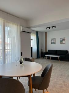 Skyline apartment في سينيموريتس: غرفة معيشة مع طاولة وكراسي وأريكة