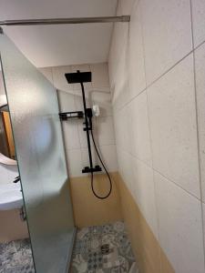 La salle de bains est pourvue d'une douche et d'une porte en verre. dans l'établissement Skyline apartment, à Sinemorets