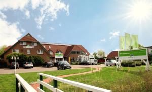 a building with cars parked in a parking lot at MP23 - Strandvogt 3 Komfort in Dorum Neufeld