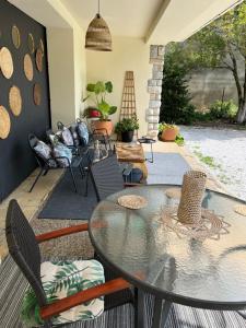 a patio with a glass table and chairs at Suite à la Villa Cattus in Bram