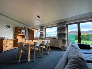 a living room with a table and chairs and a couch at EcoLodge Bungalow in Oesterdeichstrich