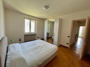 Un dormitorio con una gran cama blanca y una ventana en Casa CAPONETTI, en Costa Volpino