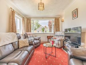 a living room with a couch and a tv at Cyrabel in Boultham