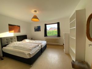 1 dormitorio con cama y ventana en EcoLodge Bungalow en Oesterdeichstrich