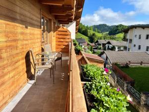 einen Balkon mit einem Tisch und Stühlen auf einem Haus in der Unterkunft Haus Marjanne in Niederau