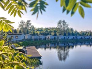 eine Reihe von Häusern am Ufer eines Sees in der Unterkunft Domki drewniane na Spławiu nad morzem in Darłowo