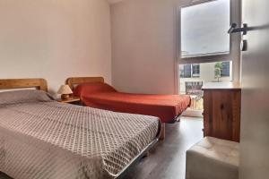 1 dormitorio con 2 camas y ventana en Confortable pavillon climatisé à 500m de la mer en Sérignan