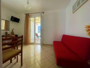 a living room with a red couch and a sliding glass door at Afroessa apartments in Mesariá