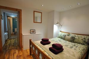 a bedroom with a bed with two red towels on it at Watersedge Apartment- cosy home by the sea in Anstruther