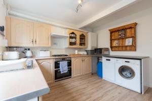 a kitchen with a washing machine and a washer at Luxury Cheltenham Home with EV charger - Lechampton Hills in Cheltenham