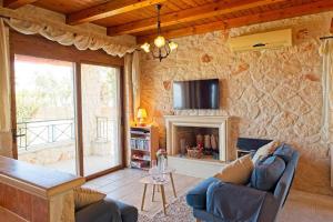 ein Wohnzimmer mit einem Sofa und einem Kamin in der Unterkunft Villa Petalouda Stunning Villa in Tragaki Zante in Tragaki