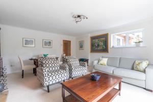 een woonkamer met een bank en een tafel bij Luxury Cheltenham Home with EV charger - Lechampton Hills in Cheltenham