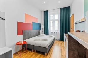 sypialnia z łóżkiem i czerwonym stołem w obiekcie Apartamenty Centrum Dworzec PKP self check-in 24h w mieście Katowice