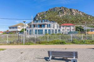 a bench in front of a fence with a house at Harbour facing Penthouse in Cape Town