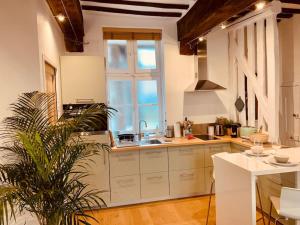 une cuisine avec des placards blancs et une grande fenêtre dans l'établissement Le Pandora, Charmant Studio - Hypercentre, à Rennes