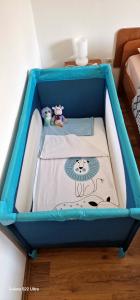 a blue and white crib with two stuffed animals in it at Apartments Barac in Poreč