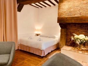 - une chambre avec un lit et une cheminée en briques dans l'établissement Le Pandora, Charmant Studio - Hypercentre, à Rennes