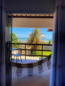 a room with a balcony with a view of the ocean at Porto Mar in São Miguel dos Milagres