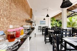 um restaurante com cadeiras pretas e mesas com bebidas em Pousada Principal em Jericoacoara