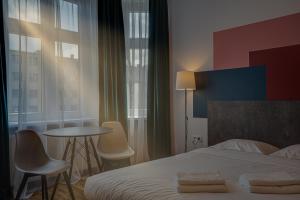 a bedroom with a bed and a table and chairs at Apartamenty Centrum Dworzec PKP self check-in 24h in Katowice