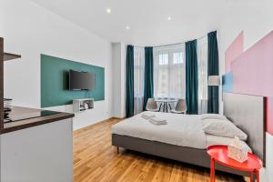 a bedroom with a bed and a red table at Apartamenty Centrum Dworzec PKP self check-in 24h in Katowice +52 photos