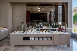 a food counter in a room with food on display at AC Hotel by Marriott San Francisco Airport/Oyster Point Waterfront in South San Francisco