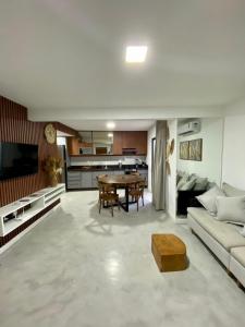 een woonkamer met een bank en een tafel bij Casasparaisomorro - 1 min da 1ra praia - Terraço com hidromassagem in Morro de São Paulo