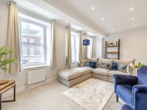 a living room with a couch and two windows at Gate House Apartment in Westerham
