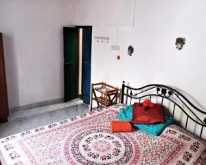 Un dormitorio con una cama con una alfombra. en Cockerel Homestay - Traditional Beach Village - Goa, en Canacona