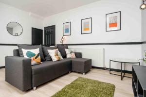 een woonkamer met een bank en een tafel bij Orange Rentals- 3 bed Scouse House Sleeps up to 8 guests in Liverpool